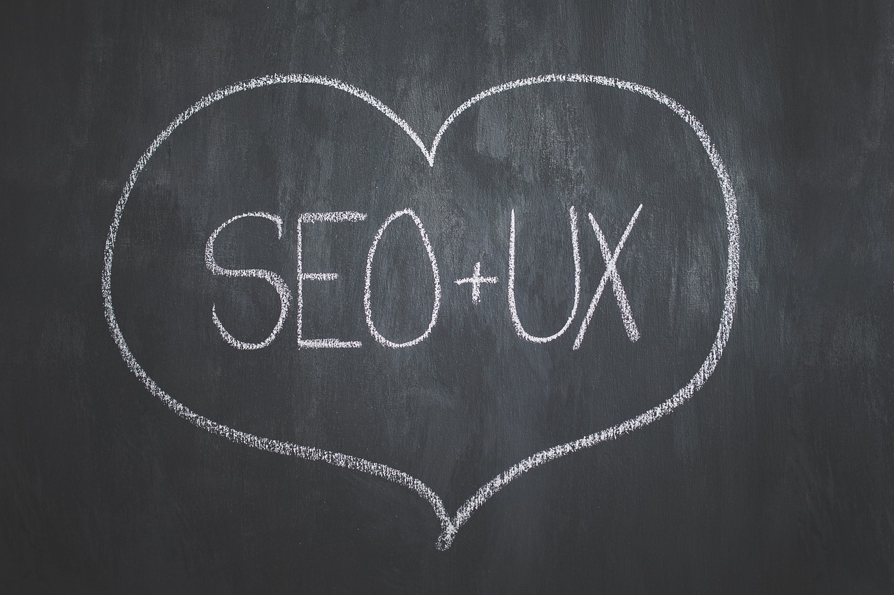 Dessin sur un tableau noir représentant un coeur avec l'inscription SEO + UX, représentant la synergie des deux domaines
